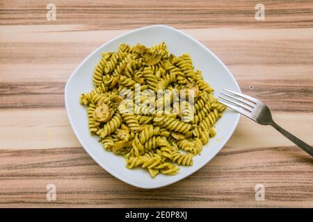 Italienische Pasta-Gericht mit gelber Sauce und Pilzen serviert Weiße Platte Stockfoto