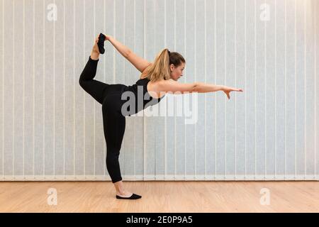 Frau Yoga-Ausbilderin zeigt die Lord of Dance Haltung in einem Fitnessraum. Stockfoto