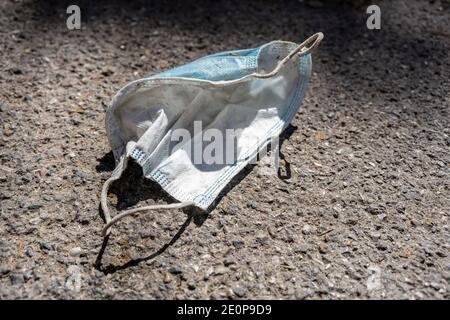 Verschwendete medizinische Maske auf dem Bürgersteig auf der Straße, Platz kopieren Stockfoto