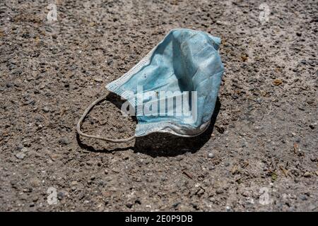 Verschwendete medizinische Maske auf dem Bürgersteig auf der Straße, Platz kopieren Stockfoto