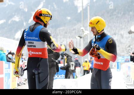 02. Januar 2021, Bayern, Schönau am Königssee: Rennrodel: WM, Doppel, Männer. Die deutschen Rennrodler Toni Eggert (l.) und Sascha Benecken klatschen auf der künstlichen Strecke am Königssee mit den Fäusten ins Ziel. Eggert und Benecken nehmen den ersten Platz ein. Foto: Tobias Hase/dpa Stockfoto