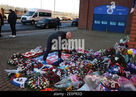 Glasgow, Großbritannien, 2. Januar 2021. Anhänger des Rangers Football Club hinterlassen Blumen und Schals an einer Gedenkstätte (Darstellung Rangers Fußballspieler John Greig) zu den 66 Fans, die ihr Leben in der Ibrox Stadion Katastrophe, die vor 50 Jahren heute am 2. Januar 1971 passiert verloren. Der Jahrestag fällt auf den Tag, an dem Rangers FC spielt ihre Rivalen Celtic FC, zu Hause, in einem Ligaspiel. Foto: Jeremy Sutton-Hibbert/Alamy Live News. Stockfoto