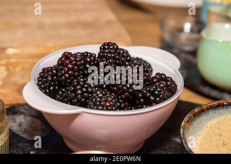 Eine Schüssel Brombeeren in einer rosa Plastikschüssel in Eine Küche bereit, gekocht werden Stockfoto