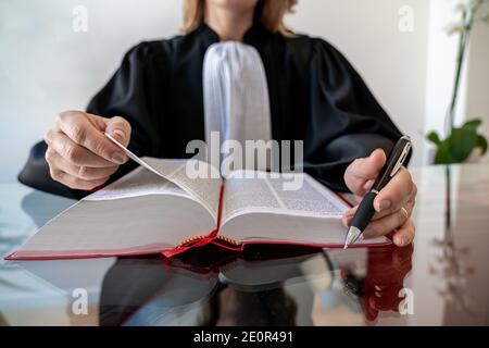 Justiz, Rechtsanwalt Frau hält und lesen offen Red Law Buch - Französisch Recht Stockfoto