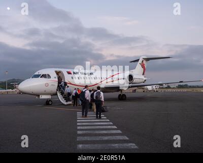 Passagiere, die einen Fokker 70 von Air Niugini am frühen Morgen am Jacksons International Airport in Port Moresby, der Hauptstadt von Papua-Neuguinea, besteigen. Stockfoto