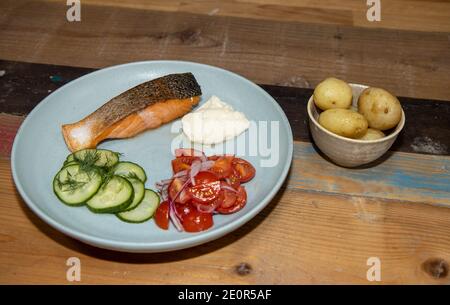 Ein köstlicher Teller Lachs und Salat in einer Küche Auf einer hölzernen Arbeitsplatte Stockfoto