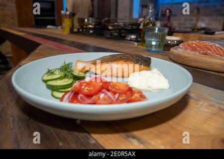Ein köstlicher Teller Lachs und Salat in einer Küche Auf einer hölzernen Arbeitsplatte Stockfoto