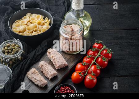 Köstliche Lumaconi Pasta-Mahlzeit mit Thunfisch und Baby Kapern, auf schwarzem Holztisch mit Platz für Text kopieren Stockfoto