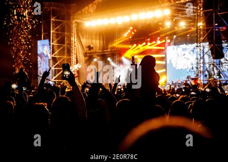 Publikum bei einem Konzert. Hände und Smartphones vor der Bühne Stockfoto