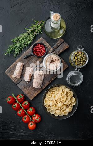 Köstliche Lumaconi Pasta-Mahlzeit mit Thunfisch und Baby Kapern, auf schwarzem Hintergrund, Draufsicht Stockfoto