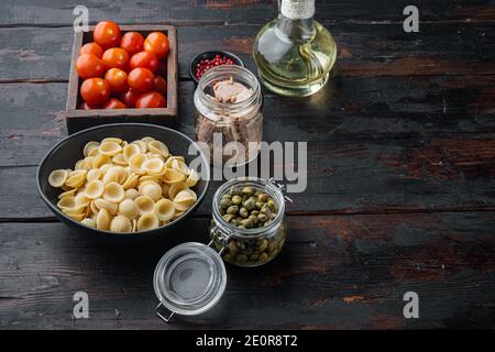 Thunfisch-Salat mit Pasta und Gemüse Zutat, auf dunklem Holzhintergrund mit Platz für Text Stockfoto