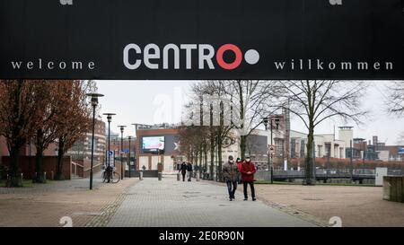 Centro, Oberhausen, NRW, Deutschland. Januar 2021. Ein paar Wanderer, wo Tausende normalerweise spazieren würden, beladen mit Einkaufstaschen. Deutschlands größtes Einkaufszentrum und die umliegenden Restaurants, Cafés und Unterhaltungsangebote wirken düster und menschenleer, die Eingänge sind abgesperrt und geschlossen. Das beliebte Einkaufszentrum mit 125.000 m² Gewerbefläche und der gesamten Außenfläche würde normalerweise mit Käufern auf der Suche nach Schnäppchen in den Januar-Verkäufe hallten. Kredit: Imageplotter/Alamy Live Nachrichten Stockfoto