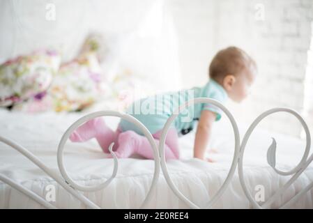 Porträt eines krabbelnden Babys auf dem Bett in ihrem Zimmer Stockfoto