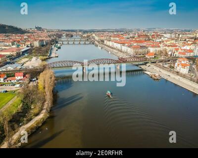 Eisenbahnbrücke zwischen Vyton und Smichov Bereich über Moldaufluss mit anderen Brücken, Altstadt und Prager Burg im Hintergrund Stockfoto