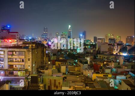 Pulsierende Nachtansicht auf Ho Chi Minh City, Vietnam, mit einer Mischung aus modernen Wolkenkratzern und dicht gepackten städtischen Gebäuden, die von farbenfroher Stadt beleuchtet werden Stockfoto
