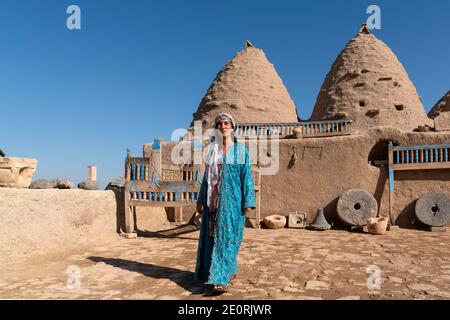 Sanli Urfa, Türkei - September 12 2020: Touristen posieren in lokaler Kleidung vor harran Häusern. Stockfoto