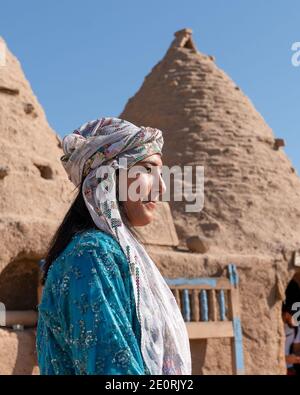 Sanli Urfa, Türkei - September 12 2020: Touristen posieren in lokaler Kleidung vor harran Häusern. Stockfoto