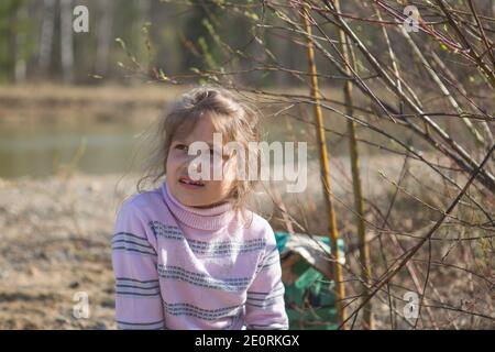 Ein kleines blondes Mädchen schaut nachdenklich in die Ferne. Stockfoto