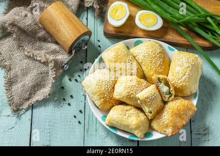 Ukrainische oder russische Küche. Gebackene kleine Kuchen mit Ei und grünen Zwiebeln, Frühling Vitamin Backwaren. Speicherplatz kopieren. Stockfoto