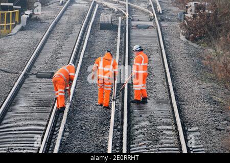 Eisenbahner enteiern die dritte Schiene einer Eisenbahn Stockfoto