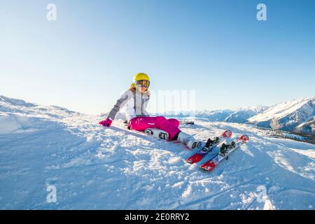 Glückliche Kinder mit Helm und Brille auf der Skipiste Stockfoto