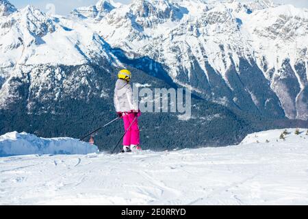 Glückliche Kinder mit Helm und Brille auf der Skipiste Stockfoto