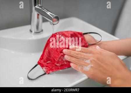 Waschtuch Maske von Hand nach einem Gebrauch. Corona Virus präventive Gesichtsbedeckung Reinigung zu Hause in Waschbecken Stockfoto