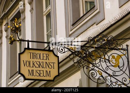 Kunstvolle Gold- und Eisenbeschilder am Eingang des Tiroler Volkskunstmuseums in Innsbruck, Österreich. Stockfoto