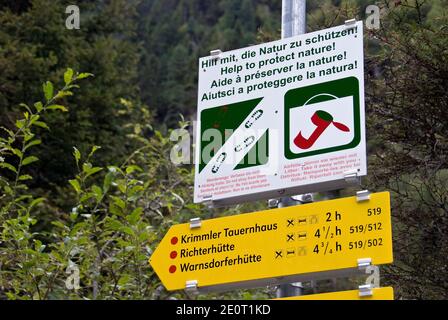 Ein Schild "Natur schützen" und Wegweiser auf dem Weg zu den Krimmler Wasserfalle, dem höchsten Wasserfall Österreichs. Stockfoto