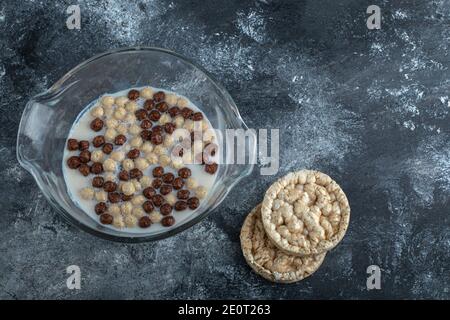 Schokoladen- und Weizenkugeln in Glasschale mit Knäckebrot Stockfoto