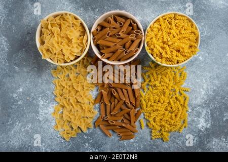 Verschiedene Arten von Pasta auf grauem Hintergrund Stockfoto