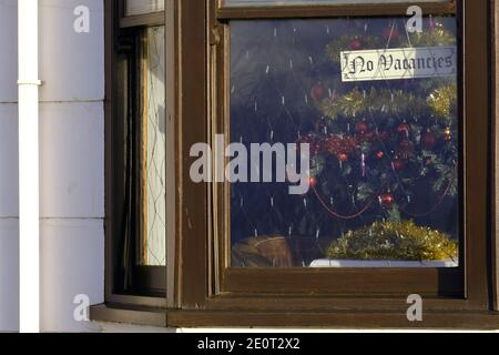 Aberystwyth, No Vakes Zeichen in einem Fenster eines Hotels mit einem Weihnachtsbaum sichtbar hinter dem Schild. Das Hotel ist wegen der Coronavirus-Sperre geschlossen Stockfoto