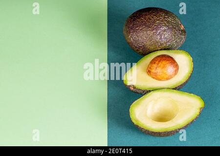 Vegetarische reife Avocado auf dem grünen Papier Hintergrund. Modell Foto, leer für Ihren Text. Stockfoto