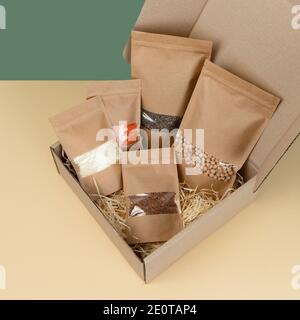 Braune Tüten aus Kraftpapier mit Lebensmittelgeschäften, Vorderansicht auf gelbem Hintergrund. Verpackung für Lebensmittel und Warenschablone Mock-up. Packungen mit Fenstern Stockfoto