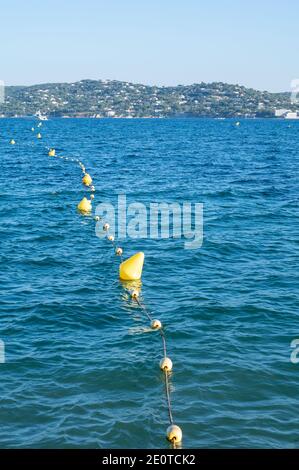 Blaues Wasser des Golfs von Saint-Tropez mit Umrissen der Stadt Saint-Tropez im Hintergrund, Französische Riviera, Frankreich im Sommer Stockfoto