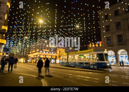 Abstrakte verschwommene Weihnachtslichter namens Lucy am beleuchteten Paradeplatz in Zürich. Millionen von hängenden Diamanten zur weihnachtszeit in der Nacht. Stockfoto