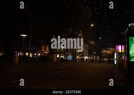 Blick auf den Hauptbahnhof zürich und die Bahnhofstrasse zur Weihnachtszeit in der Zeit des Corona Virus. Hängelampen namens Lucy, Fußgänger- und Straßenbahnweg Stockfoto