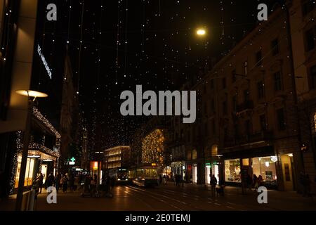 Bahnhofstrasse zur Weihnachtszeit in der Zeit des Corona-Virus. Viele Hängelampen genannt Lucy, Fußgänger und Straßenbahn am Abend. Zürich, 19. Dezember 2020 Stockfoto