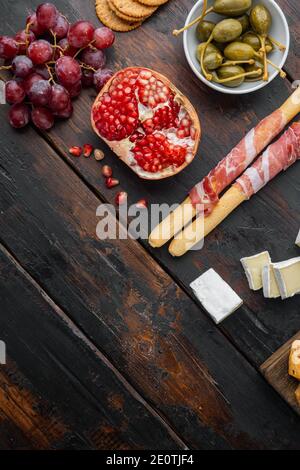 Auswahl an Käse und Fleisch Vorspeisen-Set, auf dunklem Holzhintergrund, flaches Lay mit Platz für Text Stockfoto