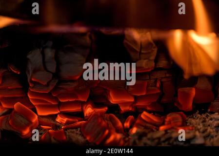 Brennendes Holz. Die Glut des Holzes brennt im Kamin. Flammen und rote Kohlen. Stockfoto