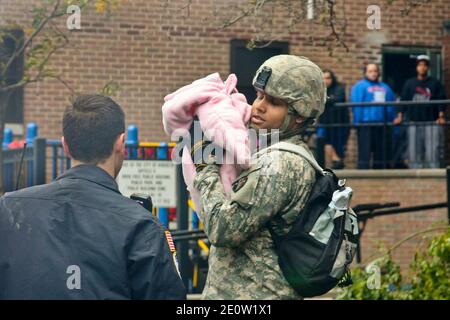 Ein Soldat hält ein Kind fest, das vom Hurrikan Sandy in Hoboken, NJ, USA, am 31. Oktober 2012 vertrieben wurde. Der Soldat wird der Nationalgarde von New Jersey zugewiesen. Foto von US Army via ABACAPRESS.COM Stockfoto