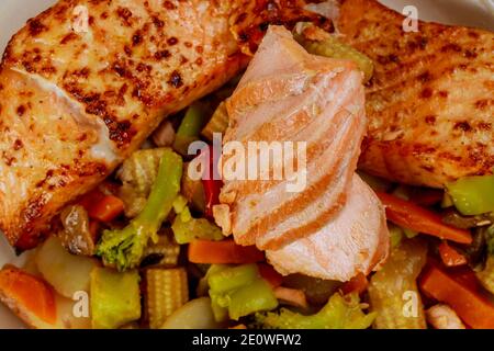 Nahaufnahme von gebackenem Lachsfilet mit gedünstetem Gemüse. Gesunde Ernährung. Stockfoto