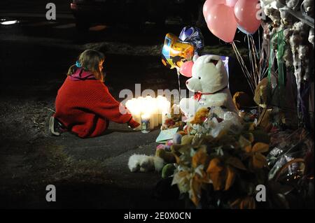 Ein Mädchen zündet am 15. Dezember 2012 Kerzen am Eingang der Straße an, die zur Sandy Hook Elementary School in Newtown, CT, USA führt. Sechsundzwanzig Menschen wurden erschossen, darunter zwanzig Kinder, nachdem ein Schütze identifiziert hatte, als Adam Lanza das Feuer in der Schule eröffnete. Lanza hatte auch angeblich Selbstmord am Tatort begangen. Eine 28. Person, die vermutlich Nancy Lanza war, wurde tot in einem Haus in der Stadt gefunden, wurde auch geglaubt, von Adam Lanza erschossen worden zu sein. Foto von Olivier Douliery/ABACAPRESS.COM Stockfoto