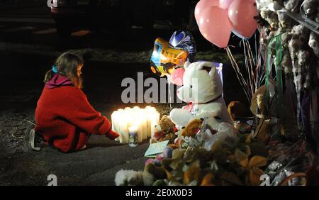 Ein Mädchen zündet am 15. Dezember 2012 Kerzen am Eingang der Straße an, die zur Sandy Hook Elementary School in Newtown, CT, USA führt. Sechsundzwanzig Menschen wurden erschossen, darunter zwanzig Kinder, nachdem ein Schütze identifiziert hatte, als Adam Lanza das Feuer in der Schule eröffnete. Lanza hatte auch angeblich Selbstmord am Tatort begangen. Eine 28. Person, die vermutlich Nancy Lanza war, wurde tot in einem Haus in der Stadt gefunden, wurde auch geglaubt, von Adam Lanza erschossen worden zu sein. Foto von Olivier Douliery/ABACAPRESS.COM Stockfoto