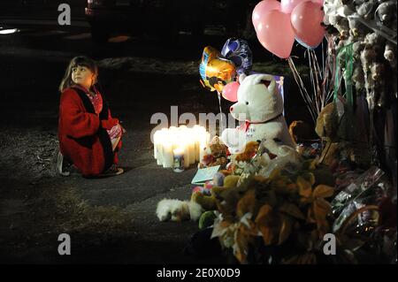 Ein Mädchen zündet am 15. Dezember 2012 Kerzen am Eingang der Straße an, die zur Sandy Hook Elementary School in Newtown, CT, USA führt. Sechsundzwanzig Menschen wurden erschossen, darunter zwanzig Kinder, nachdem ein Schütze identifiziert hatte, als Adam Lanza das Feuer in der Schule eröffnete. Lanza hatte auch angeblich Selbstmord am Tatort begangen. Eine 28. Person, die vermutlich Nancy Lanza war, wurde tot in einem Haus in der Stadt gefunden, wurde auch geglaubt, von Adam Lanza erschossen worden zu sein. Foto von Olivier Douliery/ABACAPRESS.COM Stockfoto