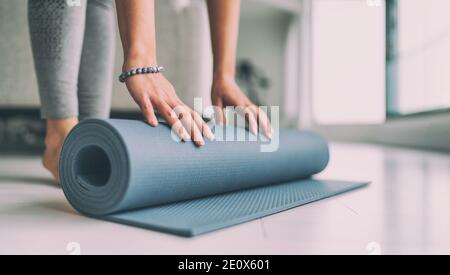 Yoga zu Hause Active Lifestyle Frau Rollen Übungsmatte in Wohnzimmer für Morgenmeditation Yoga Banner Hintergrund Stockfoto