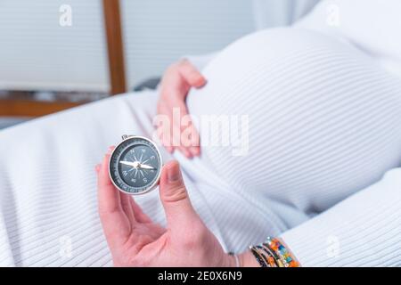 Schwangere Frau hält Kompass, Nahaufnahme Stockfoto