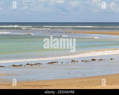 Sanfte Wellen waschen den Sandstrand an einem bewölkten späten Sommernachmittag - Torquay, Victoria, Australien Stockfoto