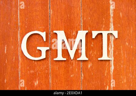 Buchstabe im Wort GMT (Abkürzung für Greenwich Mean Time) Auf alten roten Farbe Holzplatte Hintergrund Stockfoto