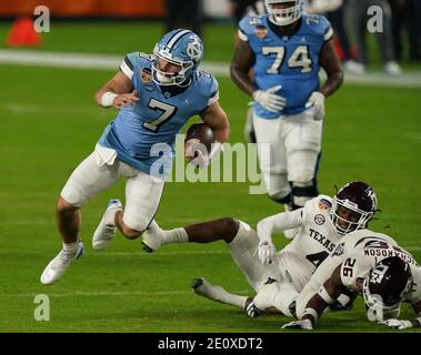 Miami, Usa. Januar 2021. North Carolina Tar Heels Quarterback Sam Howell (7) springt an Texas A&M Aggies Defensive Back Demani Richardson (26) vorbei und spielt in der ersten Hälfte des Orange Bowl in Miami am Samstag, den 2. Januar 2021. Foto von Hans Deryk/UPI Credit: UPI/Alamy Live News Stockfoto